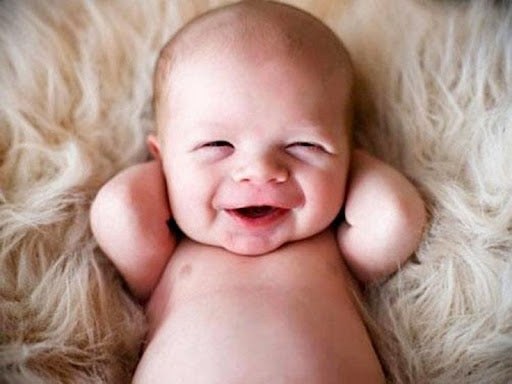 bebe relaxe bras derriere tete et souriant